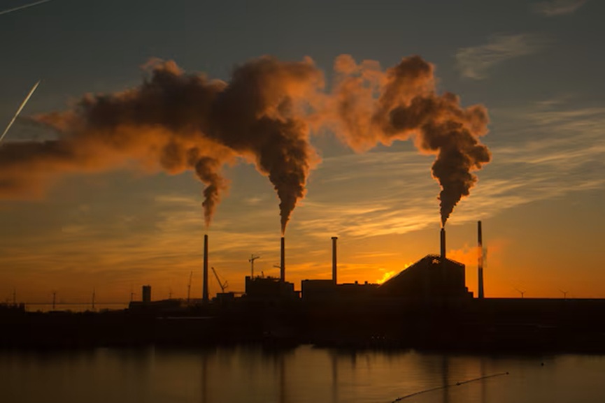 low-angle-shot-factory-with-smoke-steam-coming-out-chimneys-captured-sunset