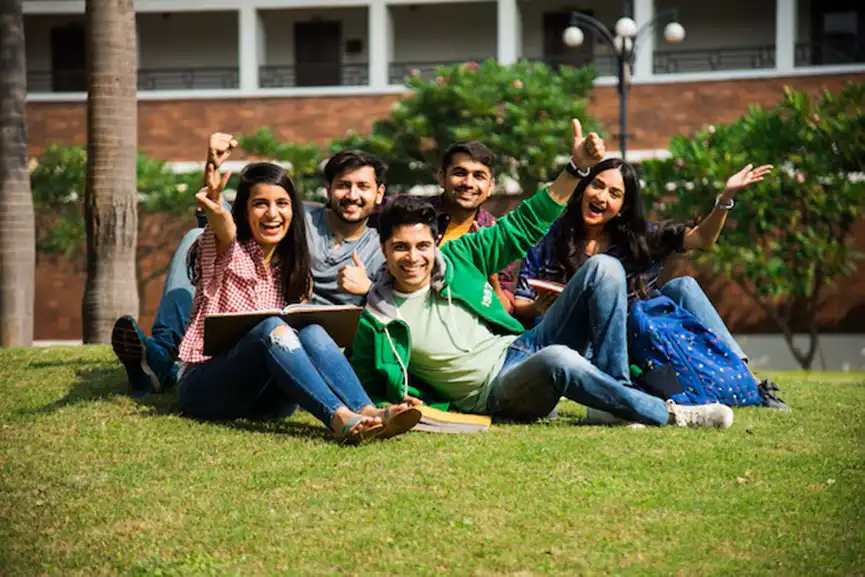 young-asian-indian-college-students-reading-books-studying-laptop-preparing-exam-working-group-project-while-sitting-grass-staircase-steps-college-campus