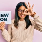young-latin-girl-holding-new-job-message-paper-smiling-happy-doing-ok-sign-with-hand-eye-looking-through-fingers