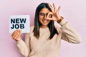 young-latin-girl-holding-new-job-message-paper-smiling-happy-doing-ok-sign-with-hand-eye-looking-through-fingers