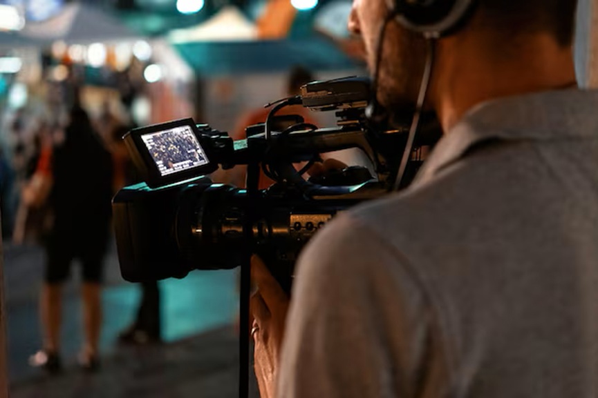 professional-cameraman-recording-poeple-watching-football-public-place-night