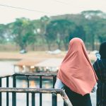 rear-view-women-standing-against-railing