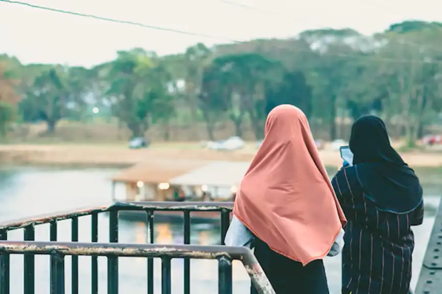 rear-view-women-standing-against-railing
