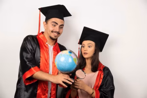 fresh-graduates-gown-looking-globe-white