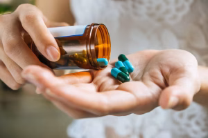 woman-s-hand-pours-medicine-pills-out-bottle