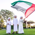 children-with-united-arab-emirates-flag-standing-grassy-field