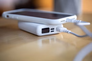 smartphone-is-charged-from-small-white-power-bank-via-cord-close-up