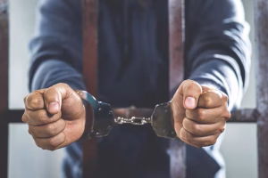 male-criminal-standing-handcuffs-lock-prison-cage-offender