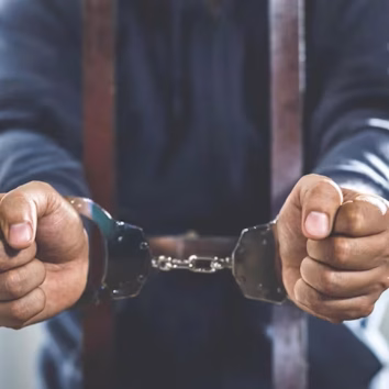 male-criminal-standing-handcuffs-lock-prison-cage-offender